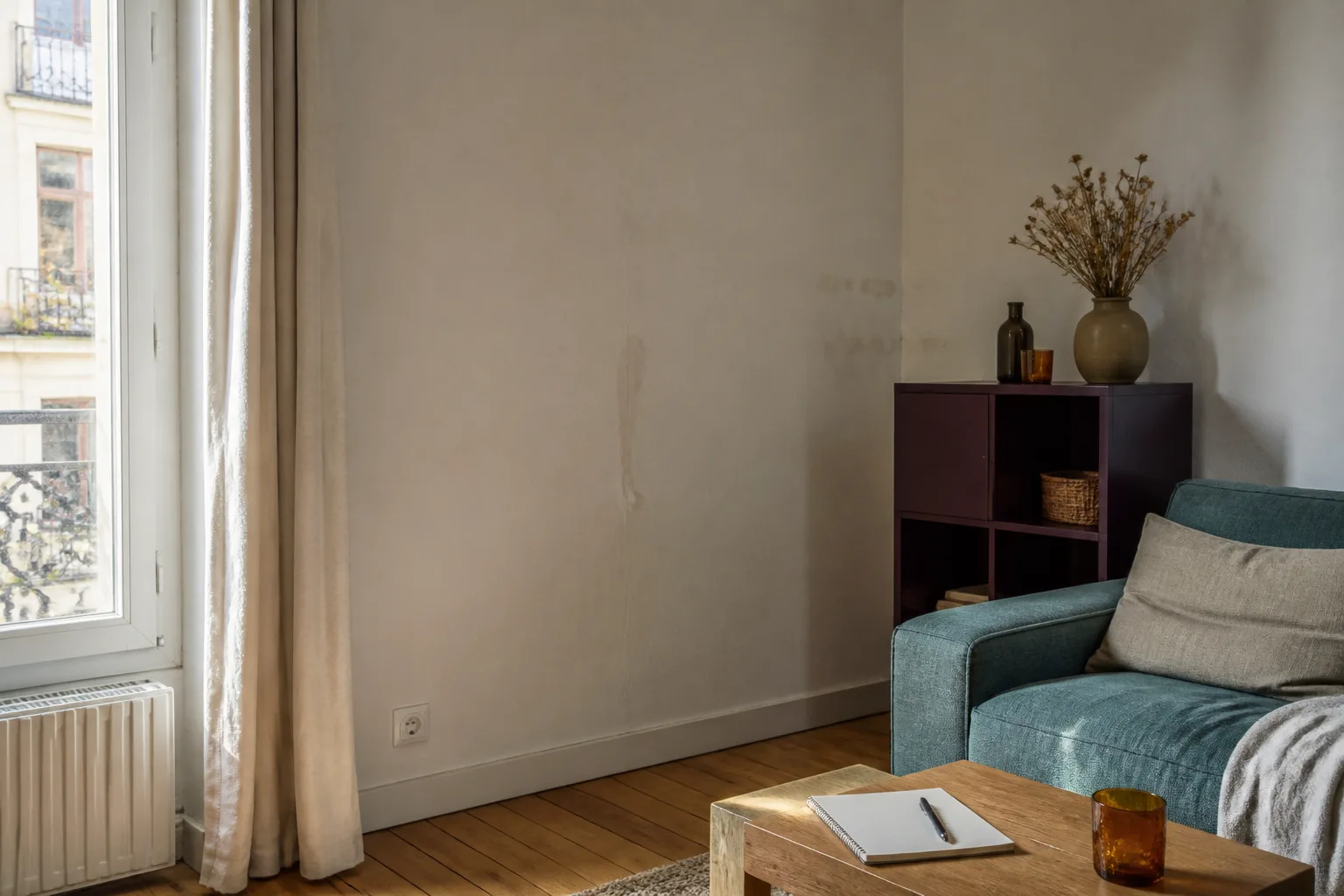 Pièce de vie observée avant projet avec fenêtre, mur et carnet